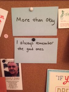 Cards pinned on a bulletin board that read 'More than Okay' and 'I always remember the good ones' also a picture of Jane Daly's brother: 'In Loving Memory Kenneth A. Gaugler Jane 27, 1952 - May 10, 2017'
